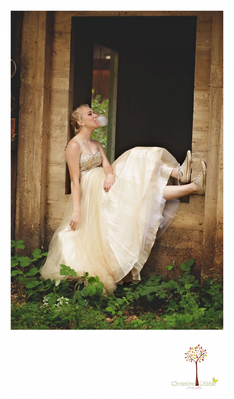 Sonora senior portrait photographer Christine Dibble Photography takes portraits of an eighth grade graduate in a formal gown as she shows her Converse shoes and blows a giant bubble with gum.