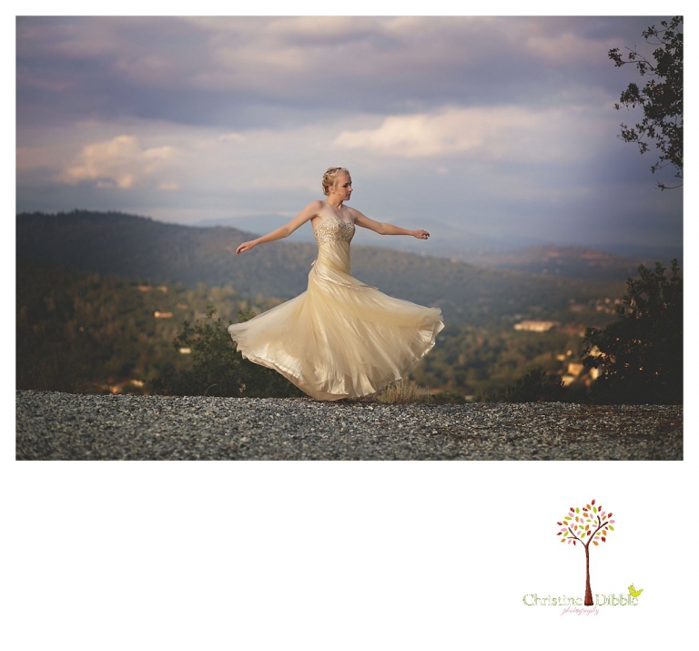 Sonora senior portrait photographer Christine Dibble Photography takes portraits of an eighth grade graduate in a formal gown as she spins on a hillside overlooking downtown Sonora.