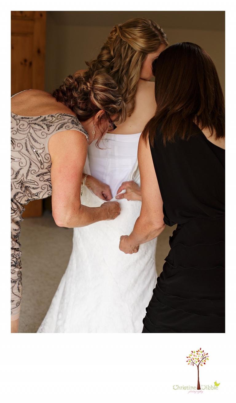 Sonora wedding photographer Christine Dibble Photography photographs a bride as her dress is zipped up before her wedding.
