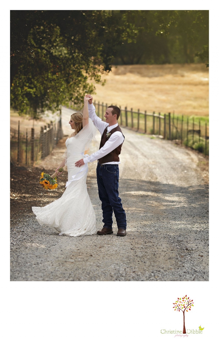 Sonora, CA wedding photographer Christine Dibble Photography takes portraits of a bride and groom as they dance on a dirt road.