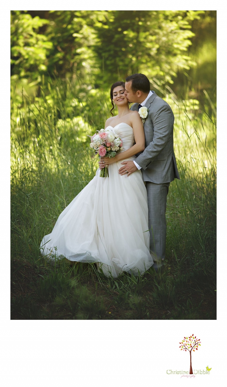 Sonora wedding photographer Christine Dibble Photography photographs a Twain Harte Tree Farm wedding and the groom kissing the bride's cheek during portraits.