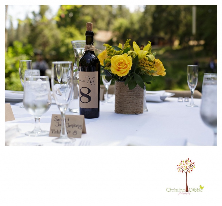Sonora wedding photographer Christine Dibble Photography photographs a Twain Harte Tree Farm wedding and the table decorations and wine bottles.