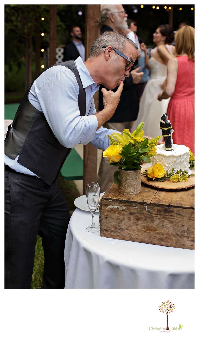 Sonora wedding photographer Christine Dibble Photography photographs a Twain Harte Tree Farm wedding and a guest licking fingers with frosting from the cake.