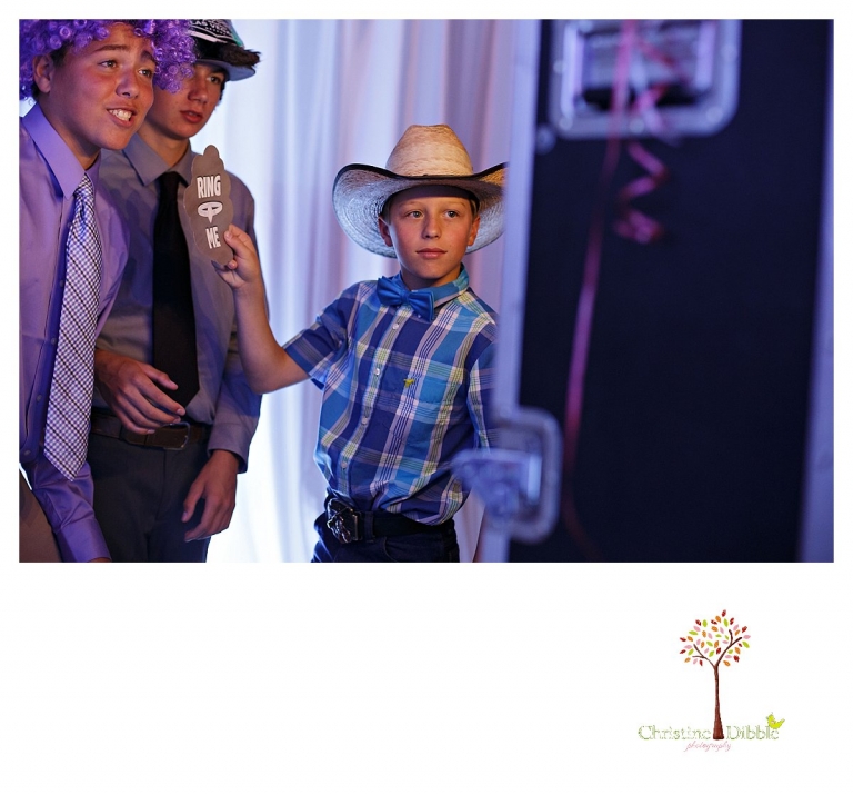 Sonora graduation and senior portrait photographer Christine Dibble Photography takes eighth grade graduation photos of a cowboy in the photo booth with friends.