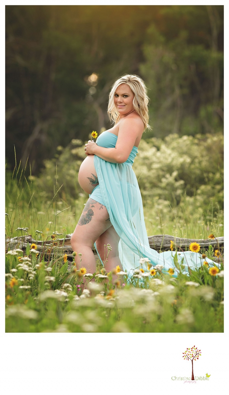 Sonora maternity photographer Christine Dibble Photography takes pregnant belly portraits of a mom in a field of wildflowers in the forest.