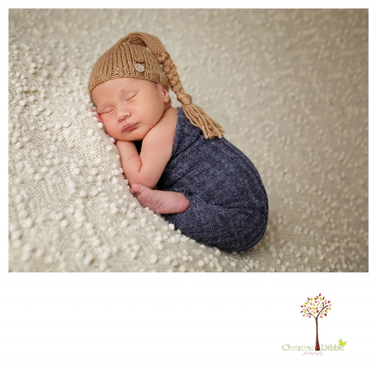 Sonora newborn and baby photographer Christine Dibble Photography takes indoor studio portraits of a baby boy in a hat and baby sock.
