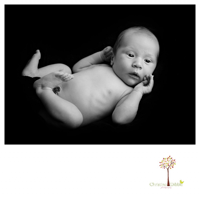 Sonora newborn and baby photographer Christine Dibble Photography takes indoor studio portraits in dramatic black and white of an awake baby.