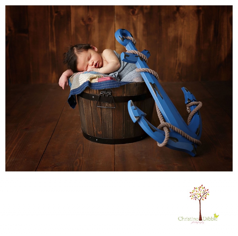 Newborn photography by best Sonora newborn photographer Christine Dibble Photography takes studio portraits of a baby boy sleeping in a bucket with an anchor prop from his nursery.