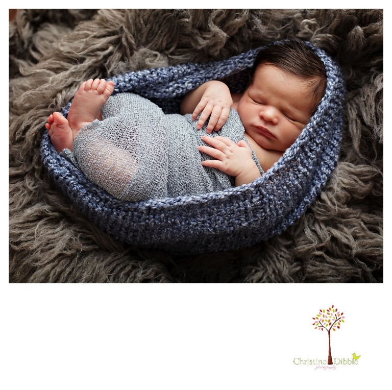 Newborn photography by best Sonora newborn photographer Christine Dibble Photography takes studio portraits of a sleeping baby boy in a wrap and coccoon in a flokati rug.