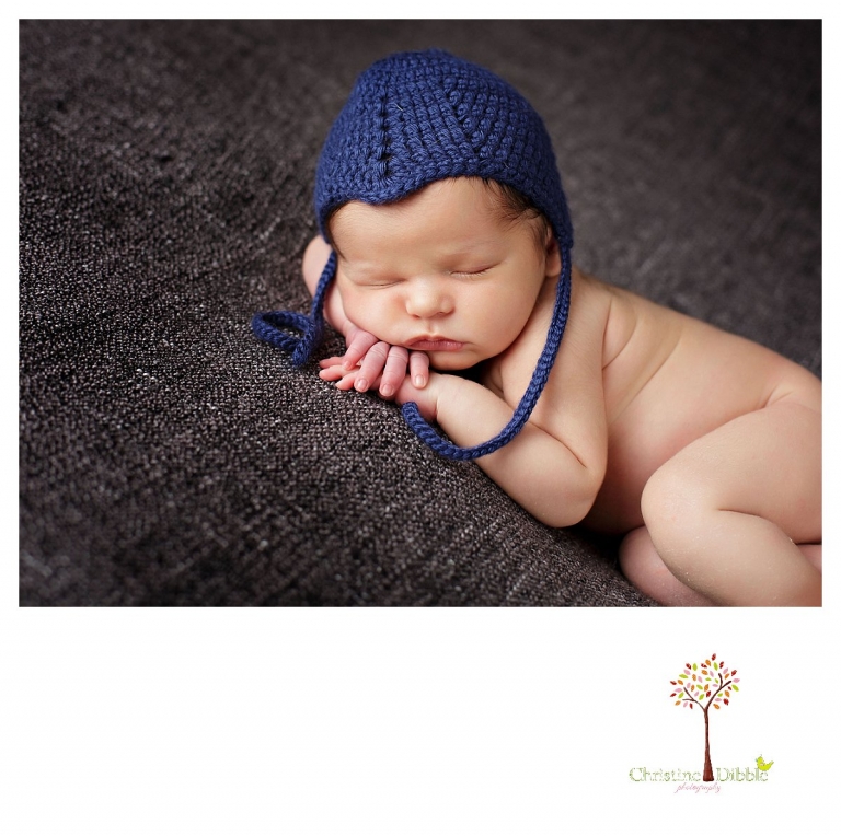 Newborn photography by best Sonora newborn photographer Christine Dibble Photography takes studio portraits of a baby boy sleeping in a blue crochet hat.