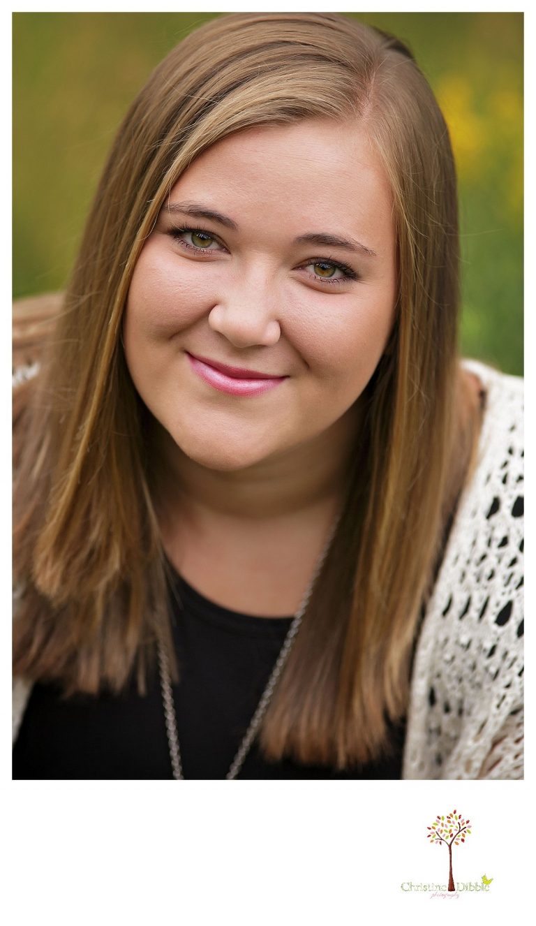 Sonora and Summerville senior portrait photographer Christine Dibble Photography takes outdoor senior portraits of a girl as she smiles for a head shot.