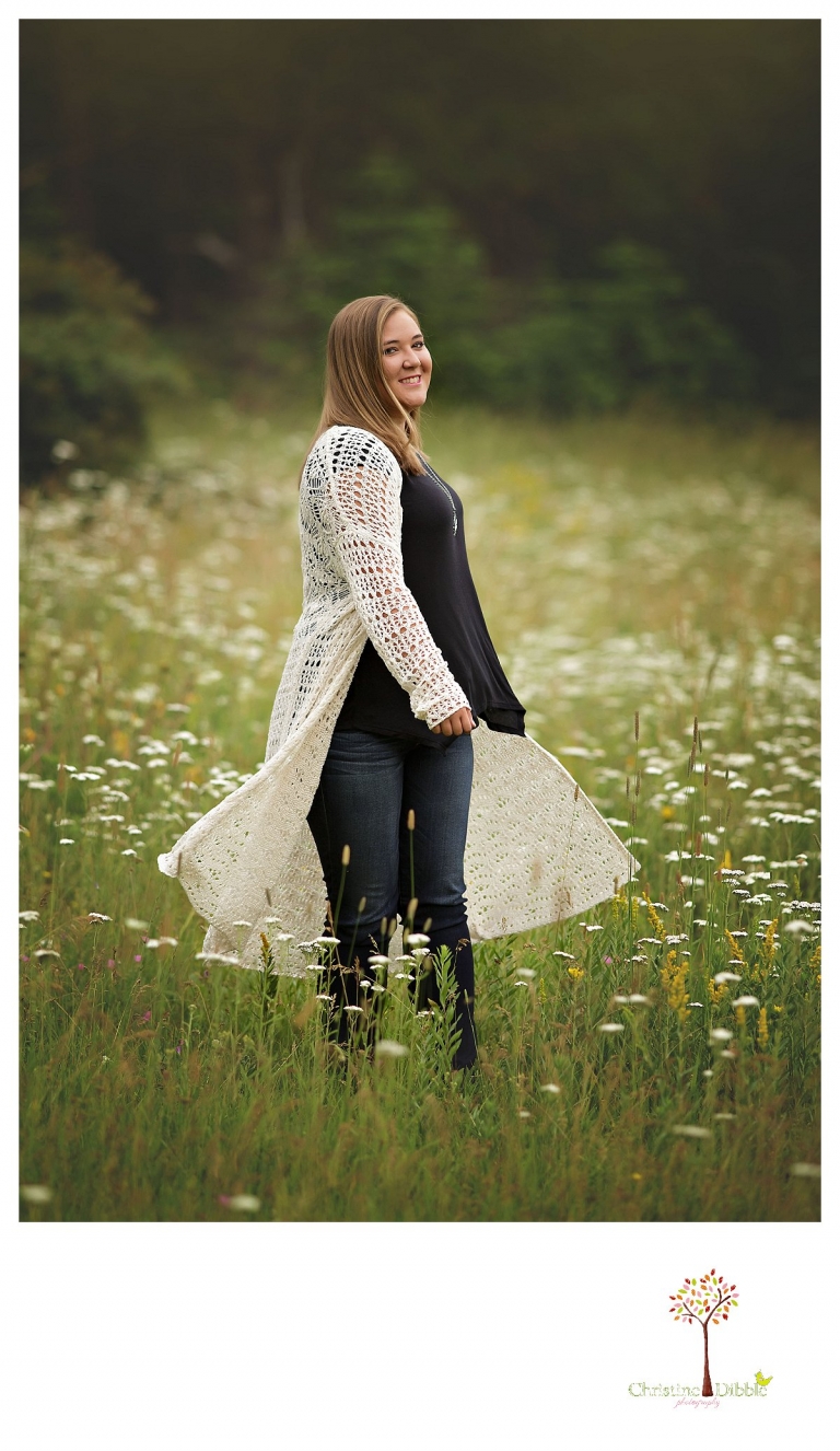 Sonora and Summerville senior portrait photographer Christine Dibble Photography takes outdoor senior portraits of a girl spinning in a field of flowers.