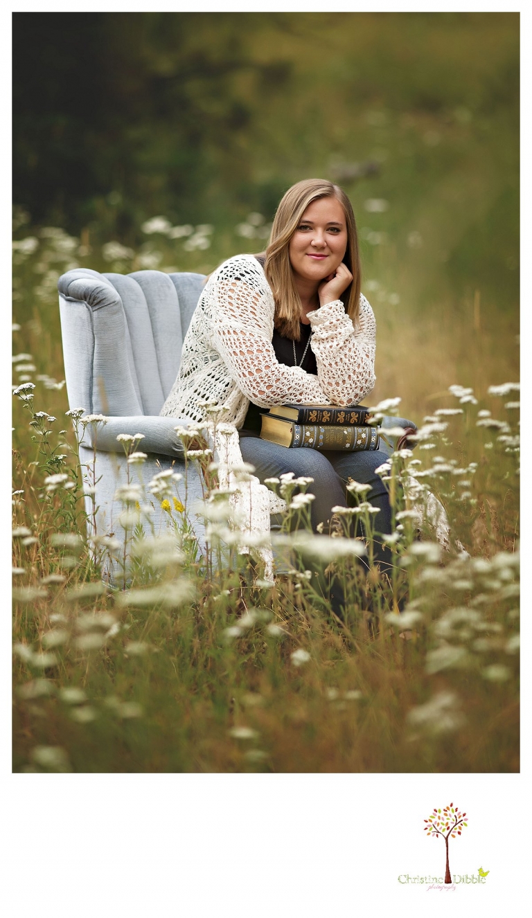 Sonora and Summerville senior portrait photographer Christine Dibble Photography takes outdoor senior portraits of a girl in a blue velvet chair in a flower field.