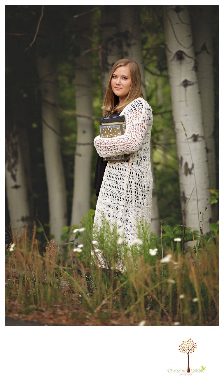 Sonora and Summerville senior portrait photographer Christine Dibble Photography takes outdoor senior portraits of a girl with her books in an aspen grove.