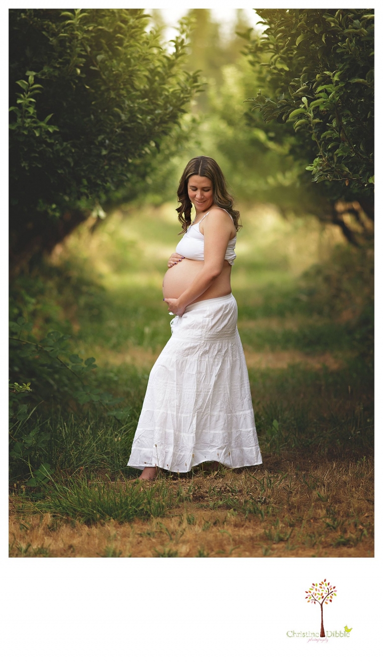 Sonora maternity photography session by Christine Dibble Photography shows a pregnant woman wearing all white and baring her belly.