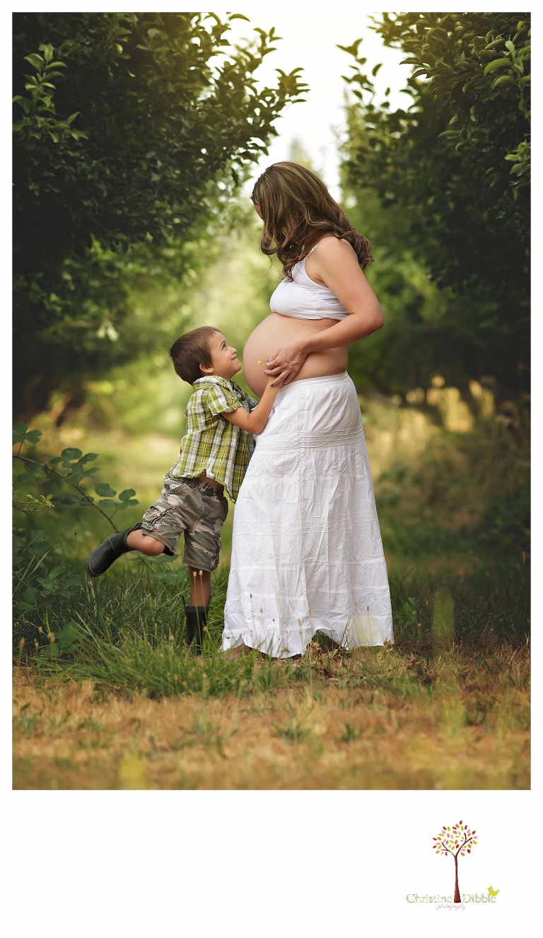 Sonora maternity photography session by Christine Dibble Photography shows a pregnant woman and her son holding her bare belly.