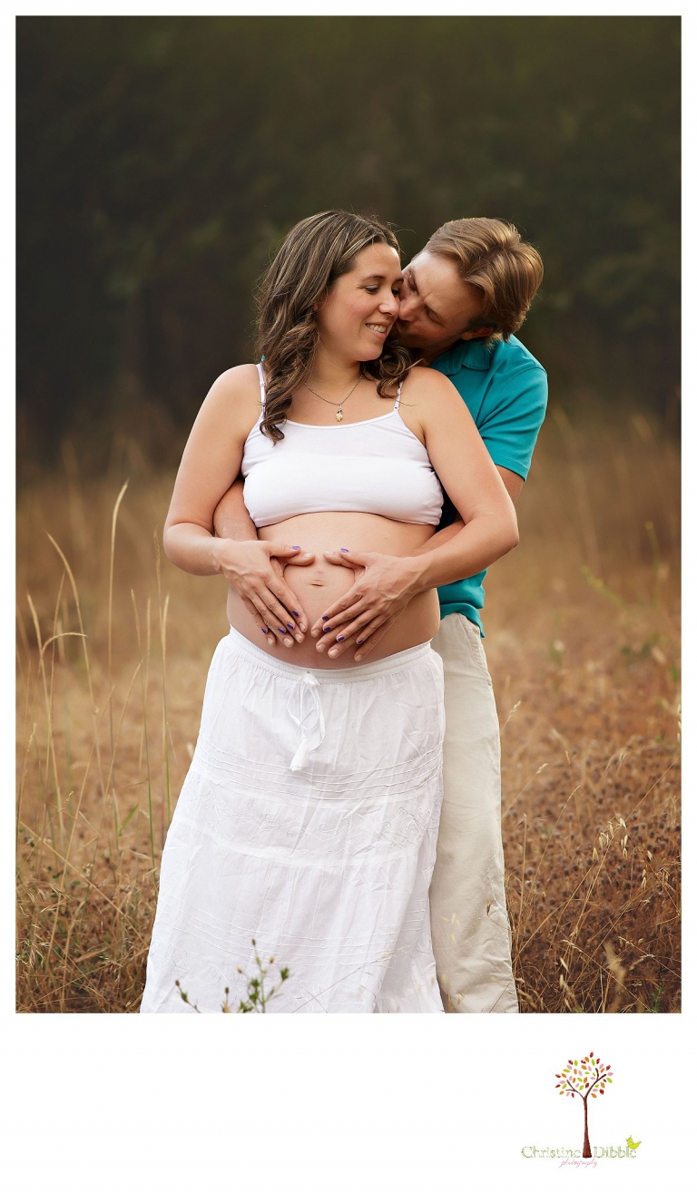 Sonora maternity photography session by Christine Dibble Photography shows a pregnant woman and dad hugging and holding the baby bump.