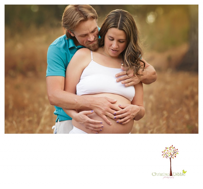 Sonora maternity photography session by Christine Dibble Photography shows a pregnant woman and dad looking at her belly.