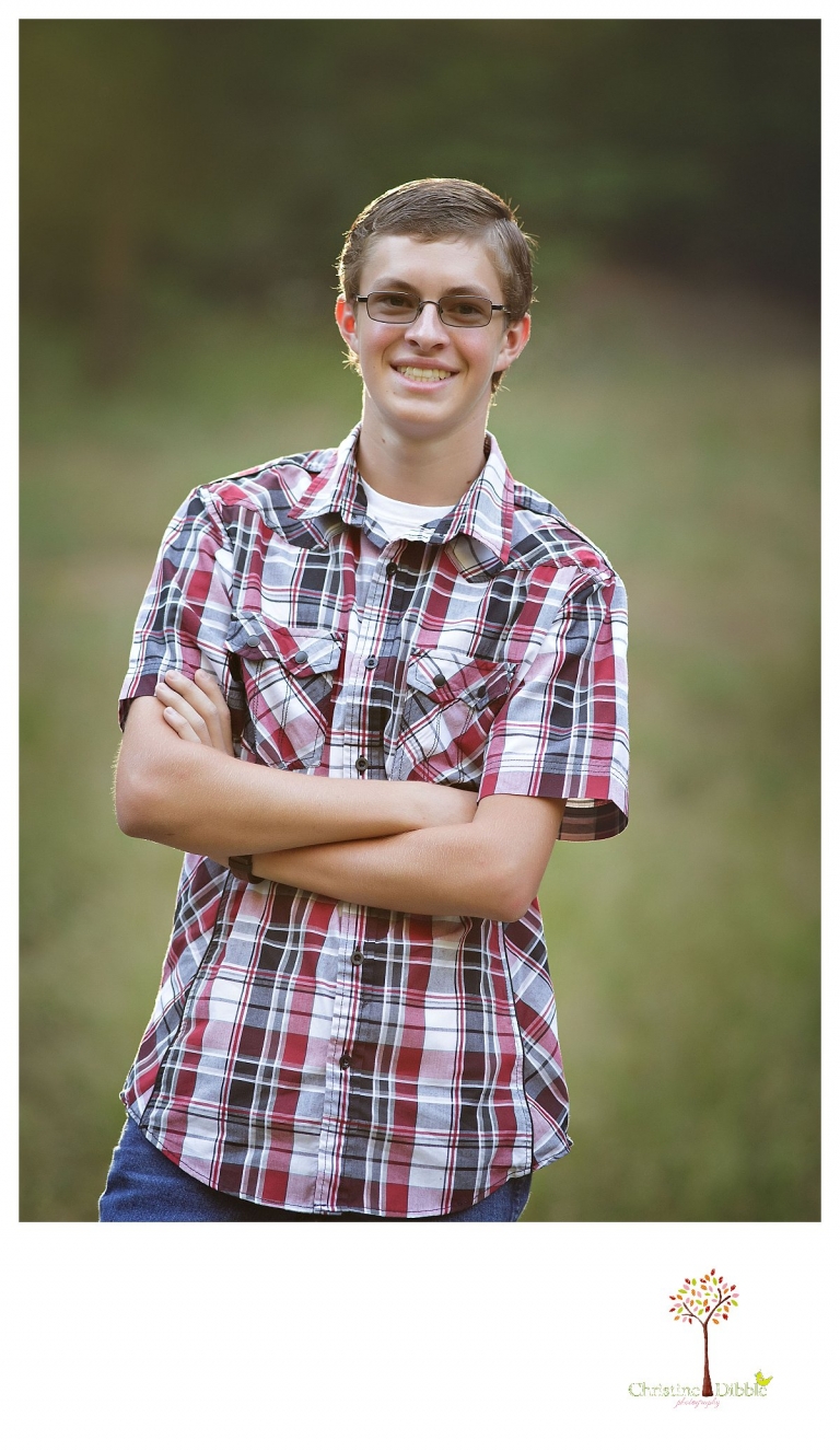 Christine Dibble Photography, Summerville and Sonora senior portrait photographer, takes photos of a senior boy in a natural setting in the woods.