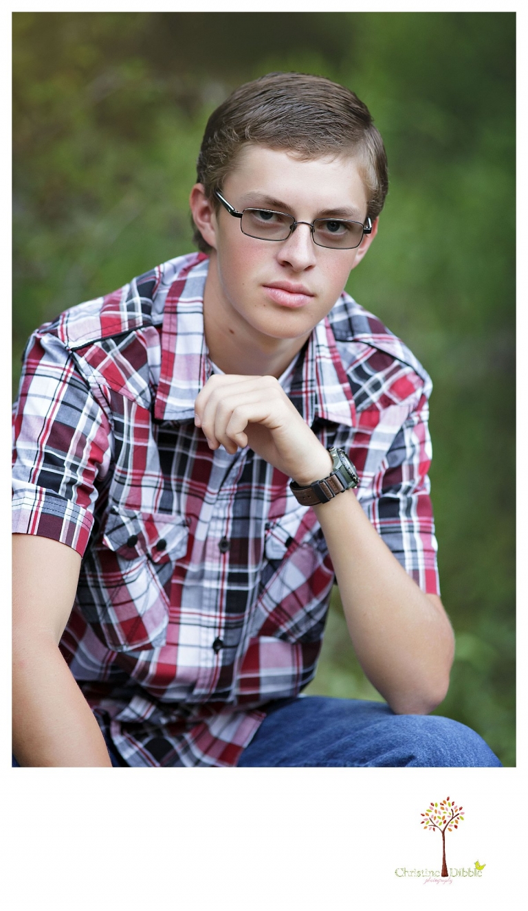 Christine Dibble Photography, Summerville and Sonora senior portrait photographer, takes photos of a boy with a green natural background setting.