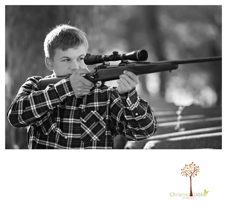 Summerville senior portrait photographer, Christine Dibble Photography of Sonora, takes a portrait of a boy sighting through the scope on his hunting rifle for a black and white image.