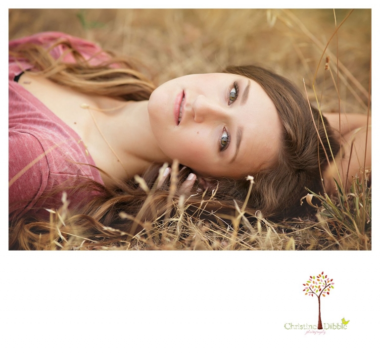 Summerville and Sonora senior portrait photographer Christine Dibble Photography takes photos of a senior girl lying in a grass field.