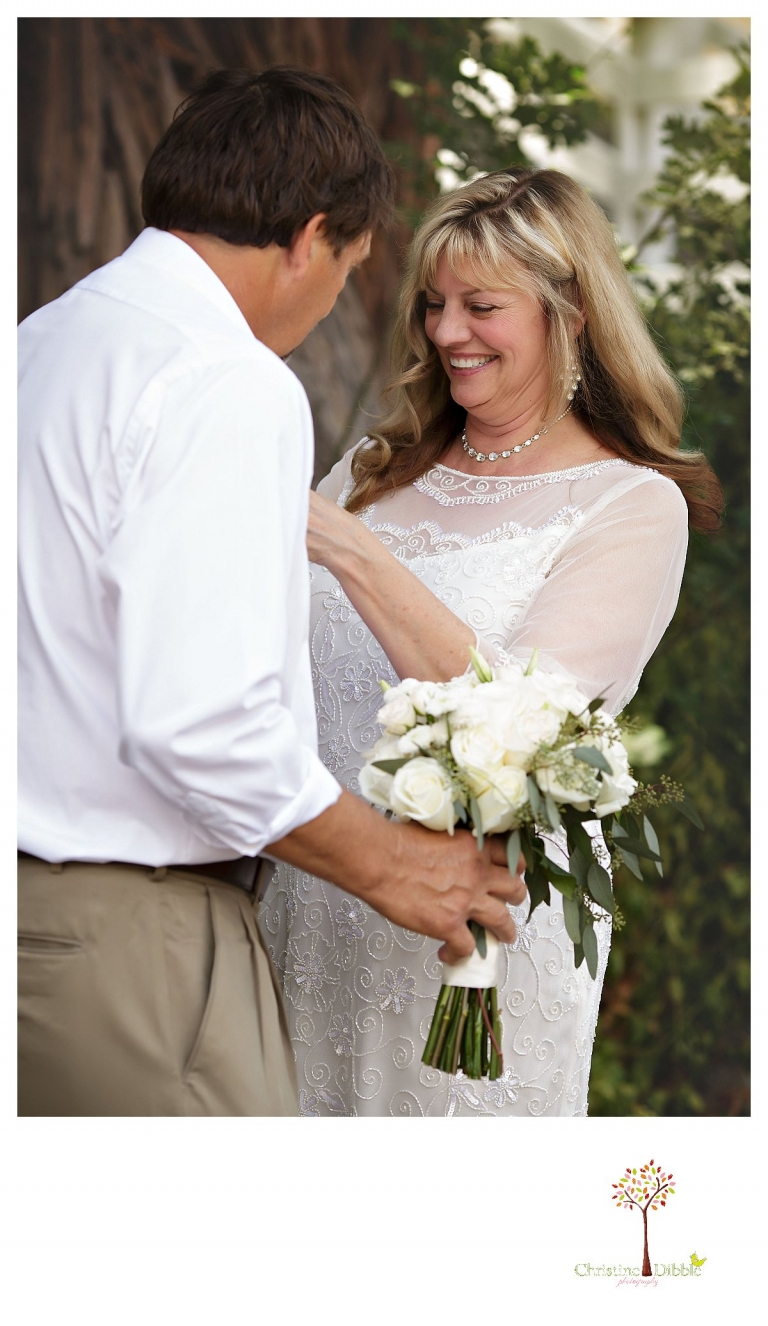 Wedding photography in Sonora by Christine Dibble Photography documents a Twain Harte Tree Farm bride pinning flowers on her groom.