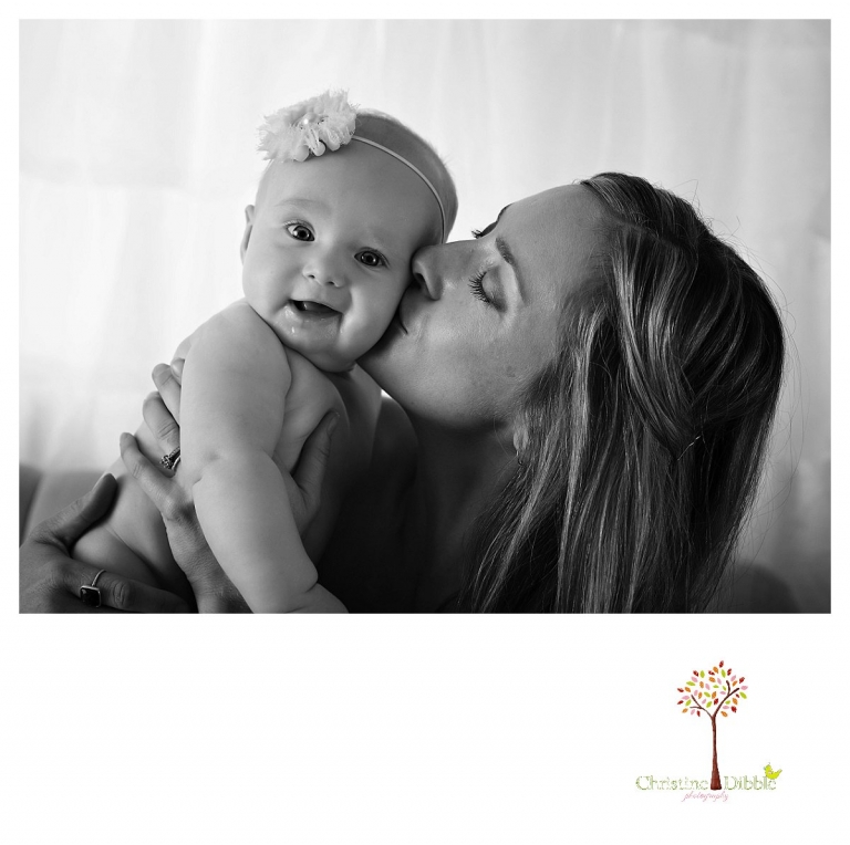 Sonora baby photographer Christine Dibble Photography takes studio portraits for a mommy and me session as a mom kisses her baby girl.