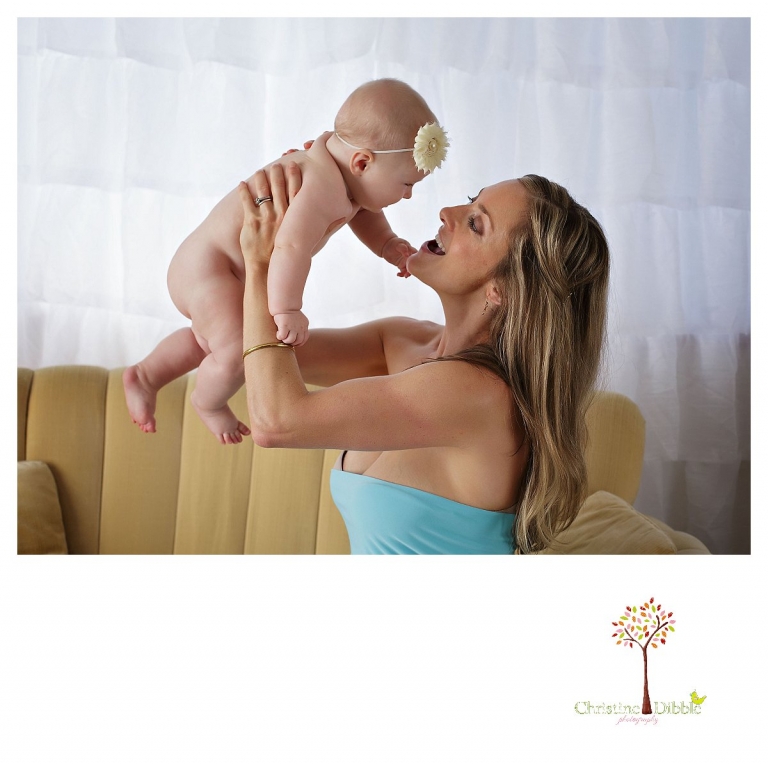 Sonora baby photographer Christine Dibble Photography takes studio portraits for a mommy and me session of a mom lifting her baby into the air.