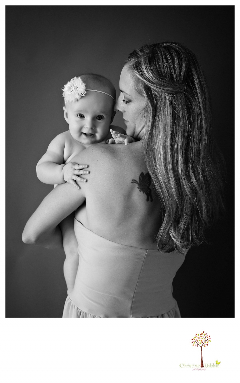 Sonora baby photographer Christine Dibble Photography takes studio portraits for a mommy and me session in black and white as mom snuggles baby.