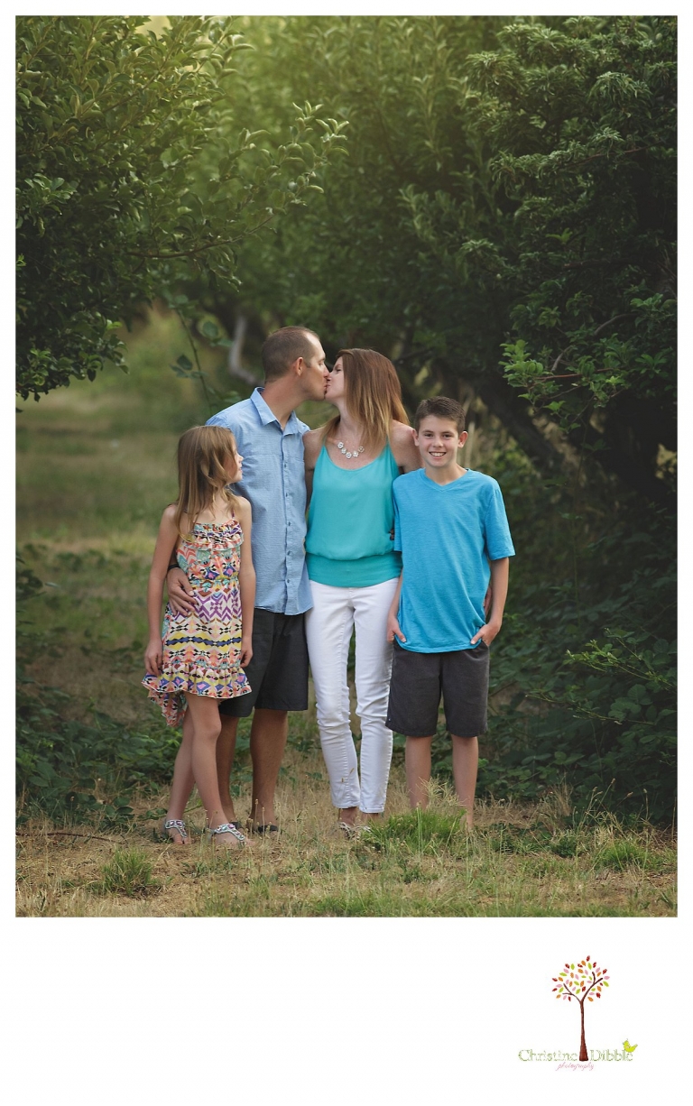 Sonora family photographer Christine Dibble Photography takes a photo of mom and dad kissing.