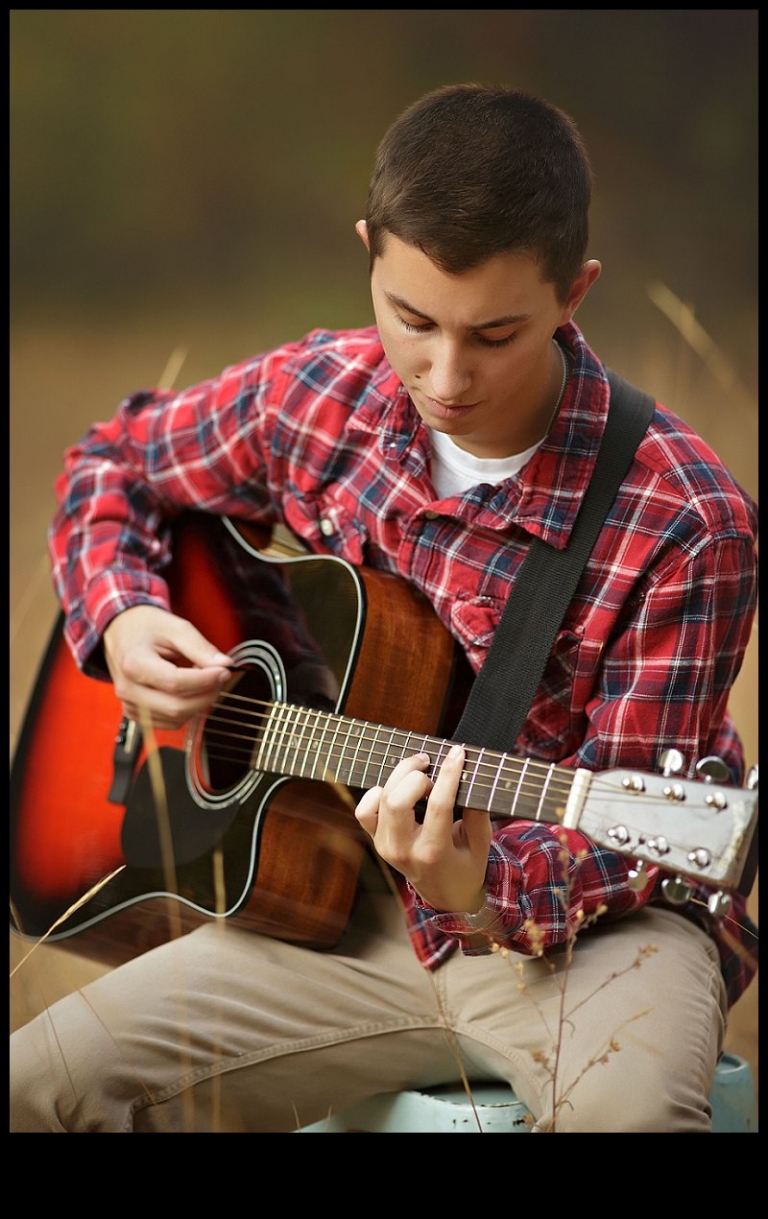 A Summerville Bear senior plays his guitar in a field near Twain Harte during a senior portrait session with Christine Dibble Photography of Sonora.