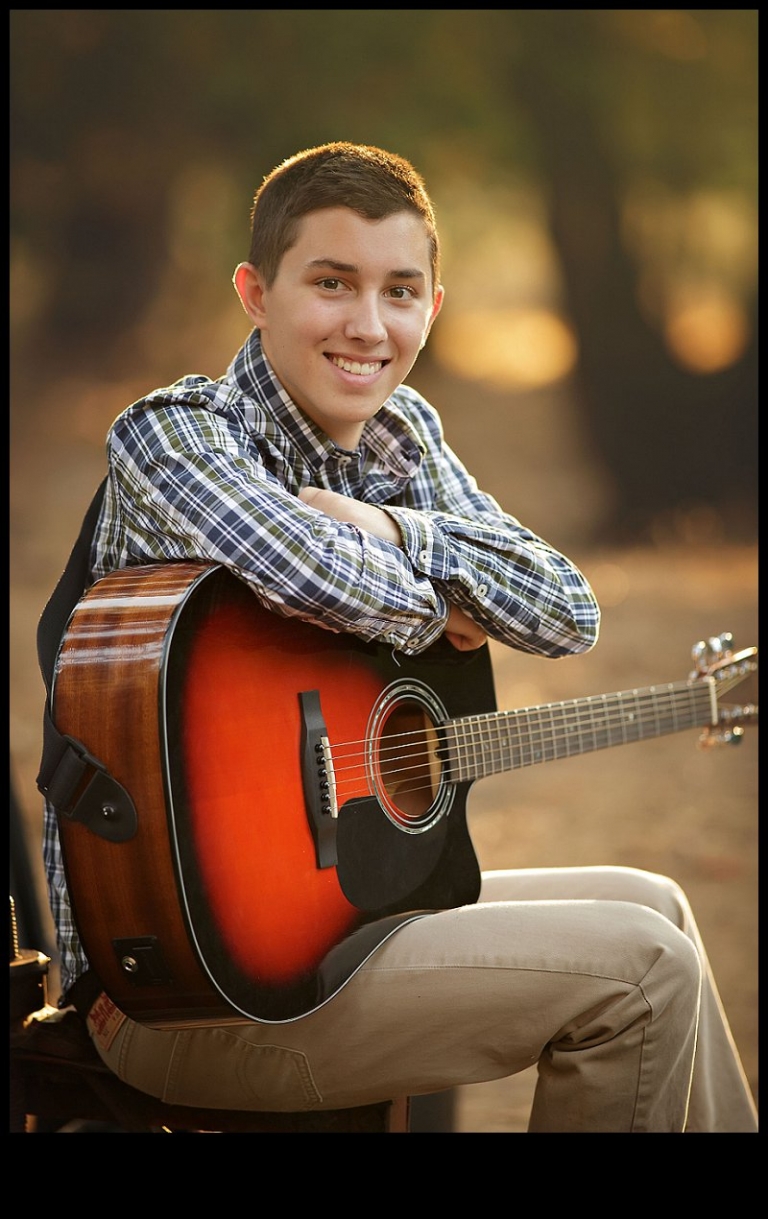 During a senior portrait session with Christine Dibble Photography of Sonora, a boy smiles with his guitar.