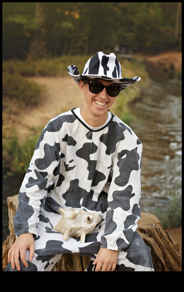 A senior boy dressed in a cow costume and shades laughs during a senior portrait session with Christine Dibble Photography of Sonora.