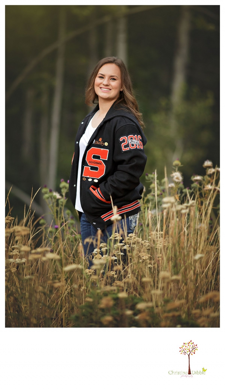 Summerville and Sonora senior portrait photographer Christine Dibble Photoraphy takes outdoor portraits of a girl in her custom letterman jacket.