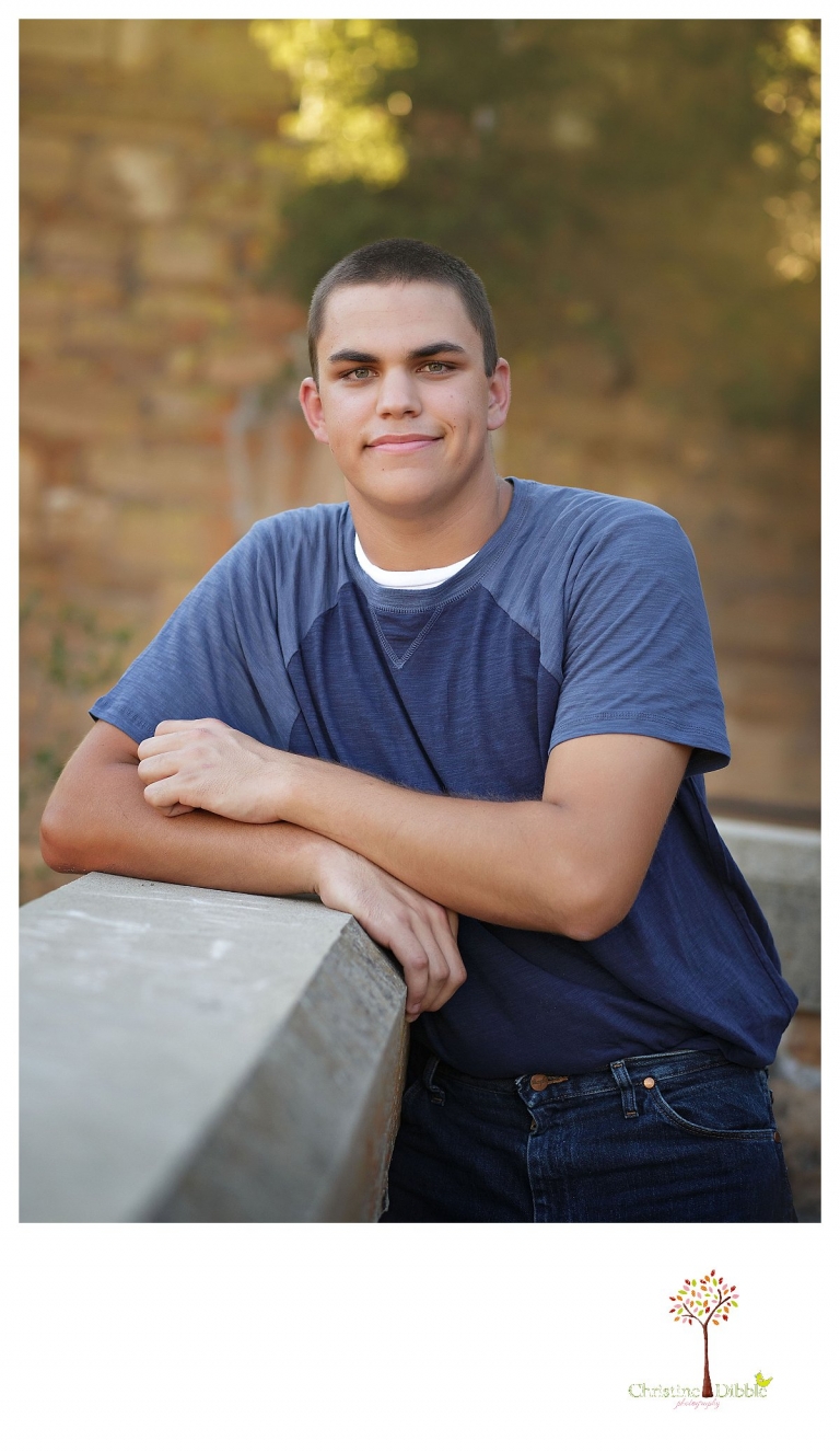 Summerville senior portrait photographer, Christine Dibble Photography of Sonora, takes photos of a senior boy at Knights Ferry as he leans on a wall.