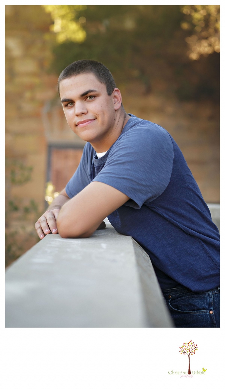 Summerville senior portrait photographer, Christine Dibble Photography of Sonora, takes photos of a senior boy at Knights Ferry as he leans on the ruins of the mill.