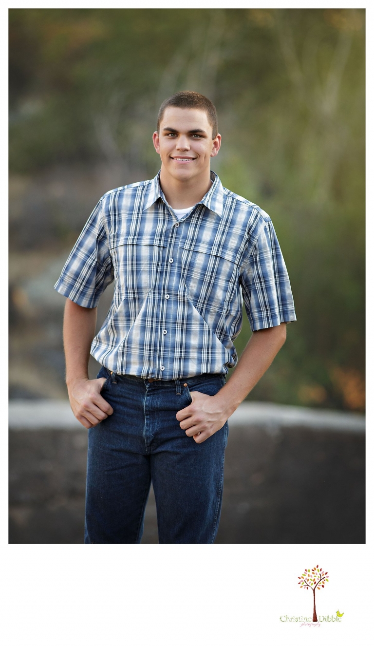 Summerville senior portrait photographer, Christine Dibble Photography of Sonora, takes photos of a senior boy at Knights Ferry with fall colors behind him.