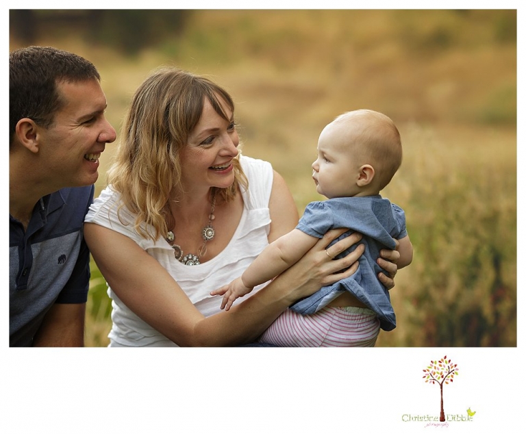 Sonora family photographer Christine Dibble Photography takes photos of parents trying to make their baby girl smile at a family portrait session at Twain Harte Tree Farm.