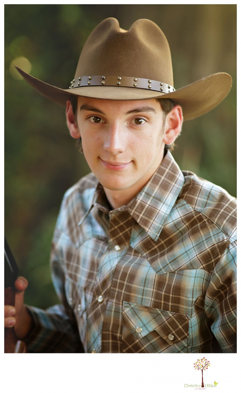 Summerville High and Sonora senior portrait photographer Christine Dibble Photography takes outdoor senior portraits of a cowboy with his trap shooting gun in his cowboy hat.