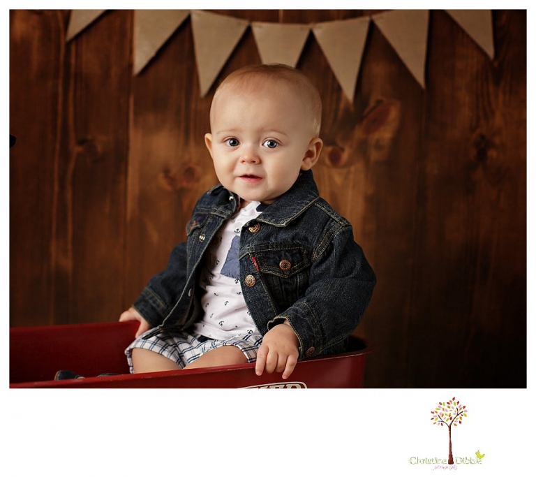Sonora baby and child photographer Christine Dibble Photography takes first year portraits in her studio of a little boy with a red wagon and vintage accessories.