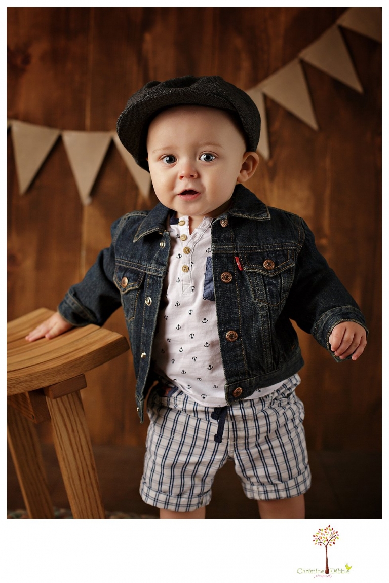 Sonora baby and child photographer Christine Dibble Photography takes first year portraits in her studio of a little boy with a red wagon and vintage accessories.