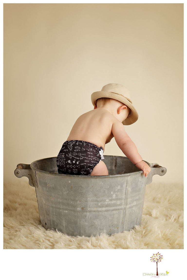 Sonora baby and child photographer Christine Dibble Photography takes first year portraits in her studio of a little boy with a red wagon and vintage accessories.