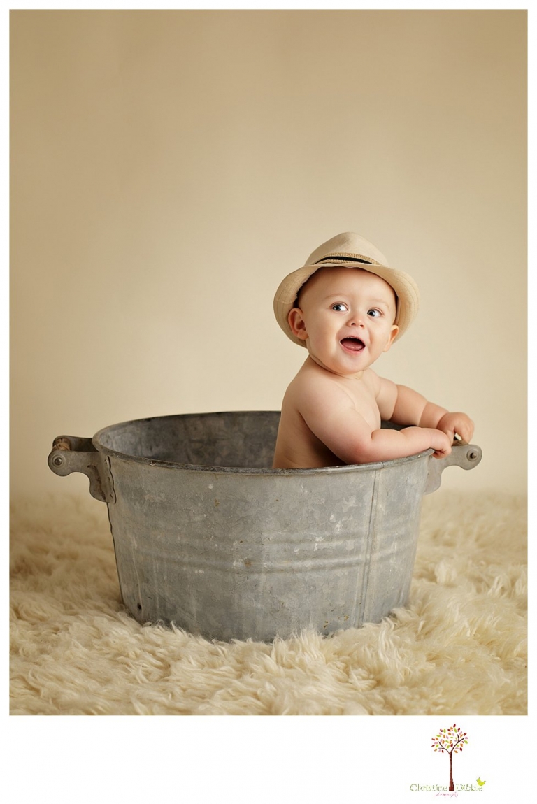 Sonora baby and child photographer Christine Dibble Photography takes first year portraits in her studio of a little boy with a red wagon and vintage accessories.