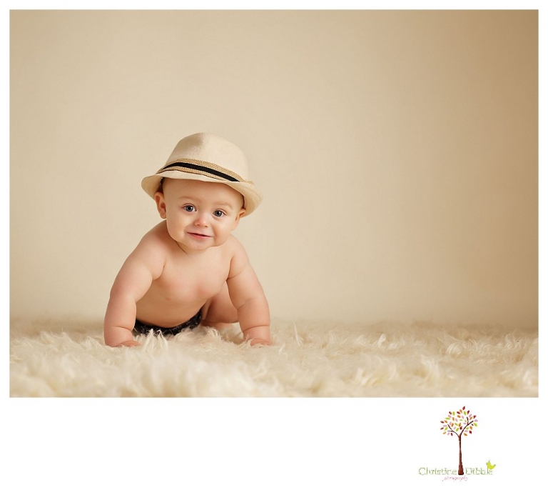 Sonora baby and child photographer Christine Dibble Photography takes first year portraits in her studio of a little boy with a red wagon and vintage accessories.