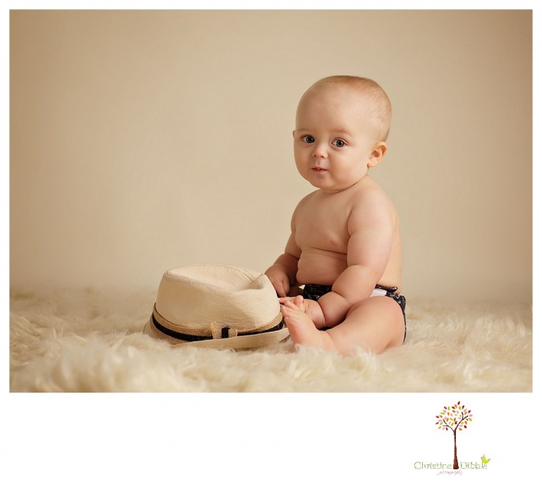 Sonora baby and child photographer Christine Dibble Photography takes first year portraits in her studio of a little boy with a red wagon and vintage accessories.