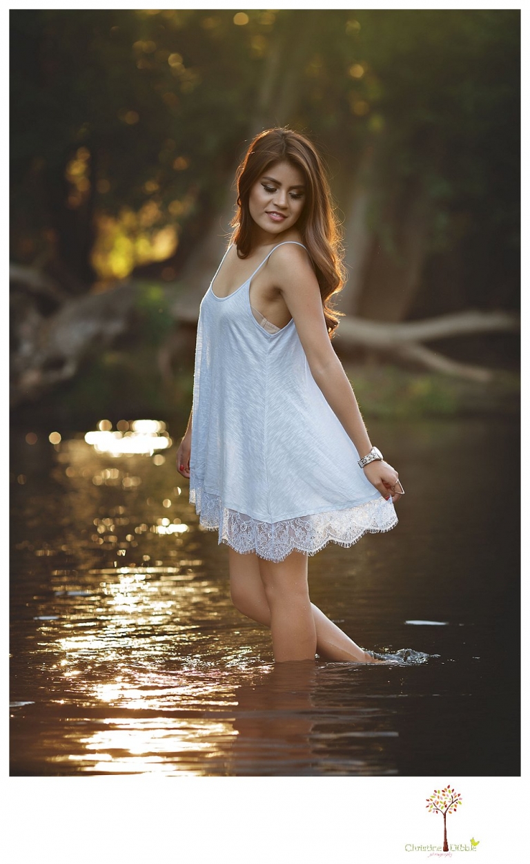 Sonora senior portrait photographer Christine Dibble Photography takes senior portraits of a beautiful Gustine High School Class of 2016 senior at Knights Ferry as she wades in the river in a dress.