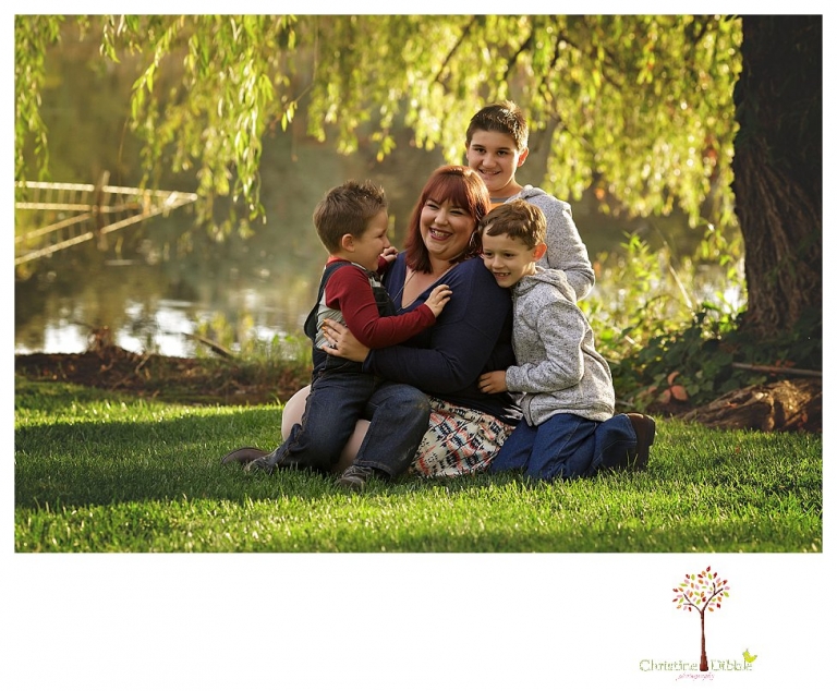 Sonora family photographer Christine Dibble Photography takes family portraits in Angels Camp of a family with three boys on private property with olive trees and a pond.