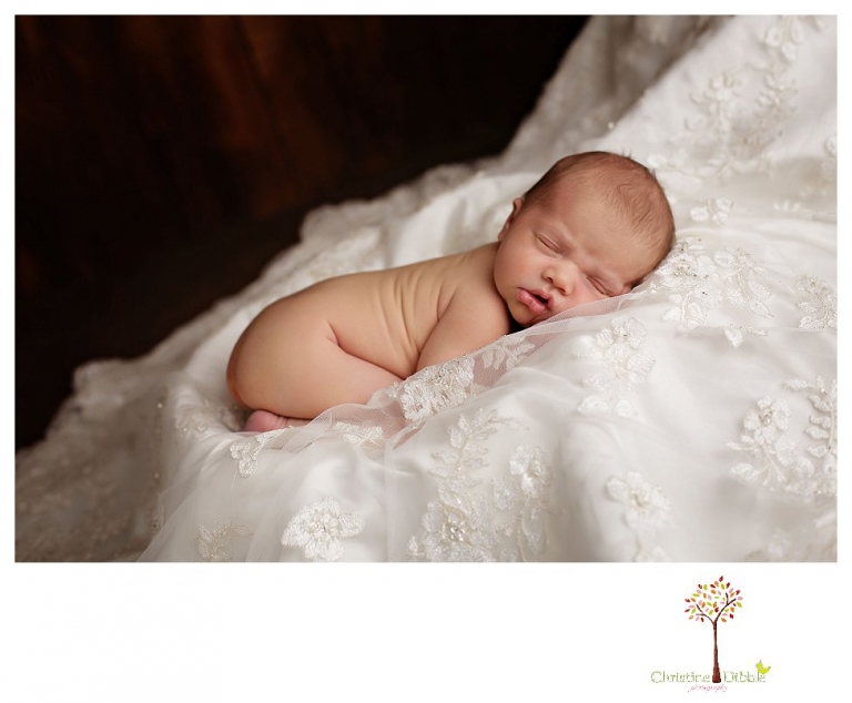 Best Sonora Newborn Photographer Christine Dibble Photography takes portraits of a sleeping newborn on blankets, in wraps and props, and on her mother's wedding dress.