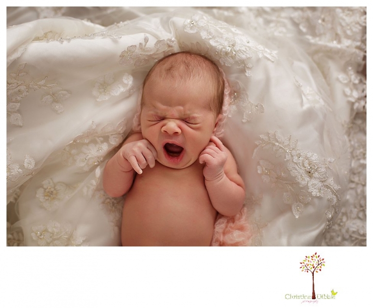 Best Sonora Newborn Photographer Christine Dibble Photography takes portraits of a sleeping newborn on blankets, in wraps and props, and on her mother's wedding dress.